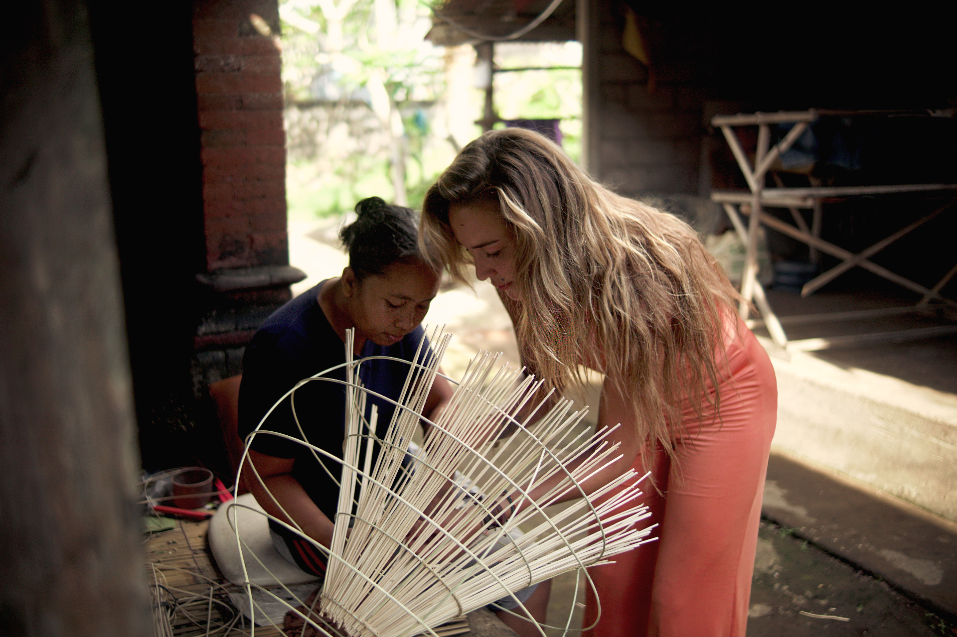 KOROOTS — working with a local Balinese craftswoman on a hand-woven rattan piece